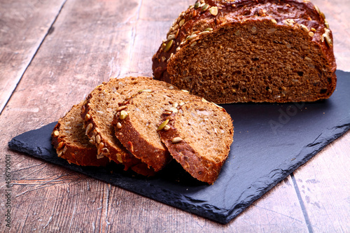 Freshly baked Pumpernickel boule rye bread on a slate serving platter