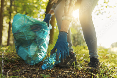 Young cleanup volunteer collecting trash in the forest