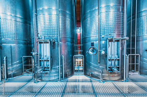 Large metal vats in which wine or beer is fermented at the factory at the winery. Concept of technologies and equipment for the production of alcoholic beverages