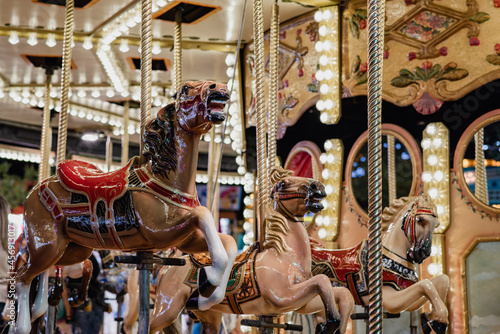 Detalle de caballos en un carrusel retro en un recinto ferial. Diversión en la feria, parque de atracciones