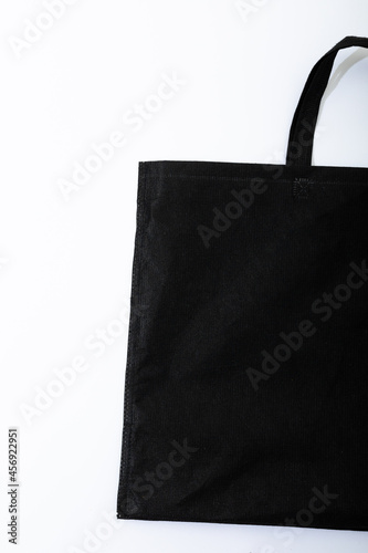Composition of empty blag canvas shopping bag lying flat on white background with copy space