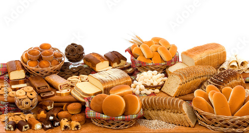 Mix de pães industrializados, bolos, rosquinhas, pães especiais tudo na mesa em fundo branco para recorte.