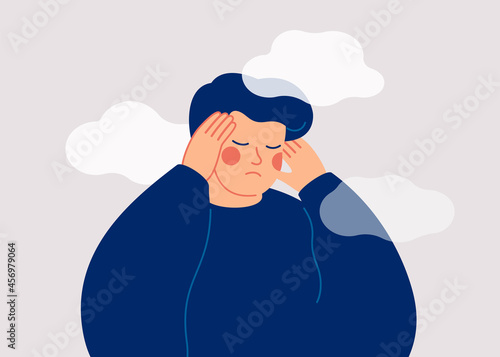 A sad young man has a clouded mind on blue background. A depressed teenager boy suffers from temporary memory loss and confusion. Vector illustration
