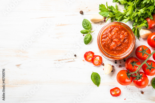 Tomato sauce. Traditional italian tomato sauce with herbs and spices at white kitchen table. Top view with copy space.