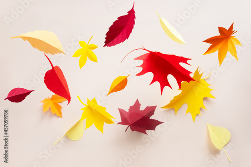 Autumn leaves cut from paper on beige background. Hello, autumn concept.