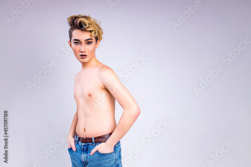 blond man with make up on face posing in studio on white background