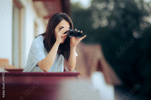 Curious Woman Holding a Pair of Binocular Spying on her Neighbors