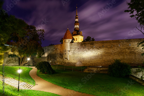Medieval city wall of Tallinn Estonia at night with fleeing clouds.