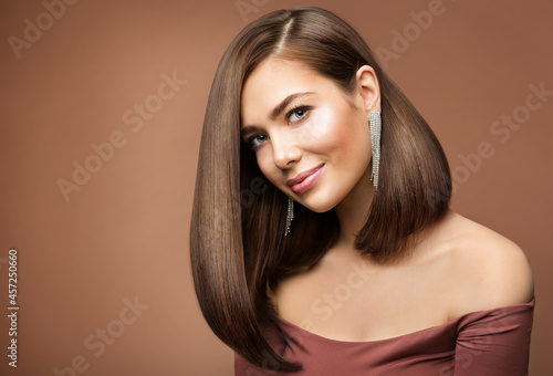 Woman Long Bob Haircut. Smiling Beauty Model with Brown Shiny Straight Hairstyle looking at Camera over brown Background