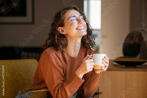 Cheerful woman enjoying coffee cup in a winter afternoon