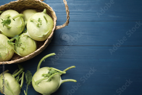 Whole kohlrabi plants on blue wooden table, flat lay. Space for text