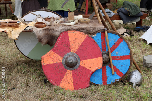 Battered Viking shields standing against a fur covered table.