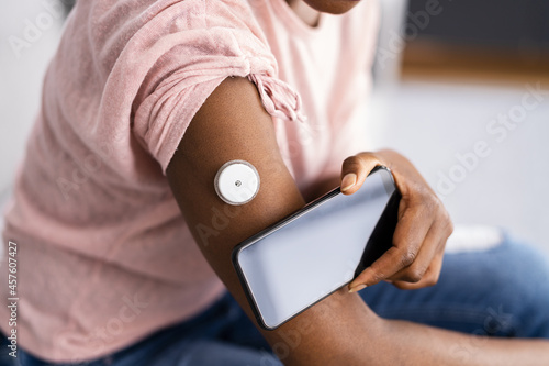 Woman Testing Glucose Level With Continuous Glucose Monitor