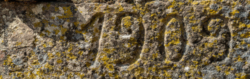 Vintage 1909 number text carved over the rock