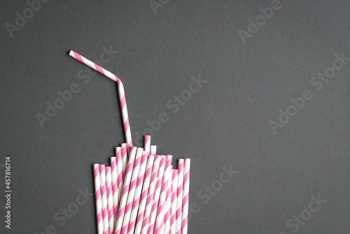 Glass with straw made up of paper straws on black background. Party or no plastic concept. 