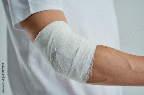male patient in a white T-shirt with a bandaged hand isolated background