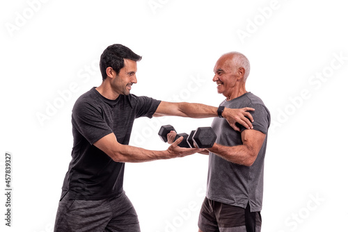 An elderly European man, with a personal trainer, trains, lifting weights, on a white background.