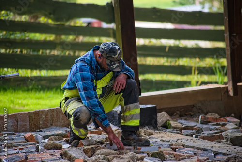 Budowa tarasu - Majster układa podbudowę z gruzu . Construction of the terrace - The foreman arranges the rubble foundation. 