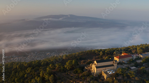 Aerial view over Mount Tavor and Church of the Transfiguration Drone view from North Israel at sunrise covered with clouds, 2021 