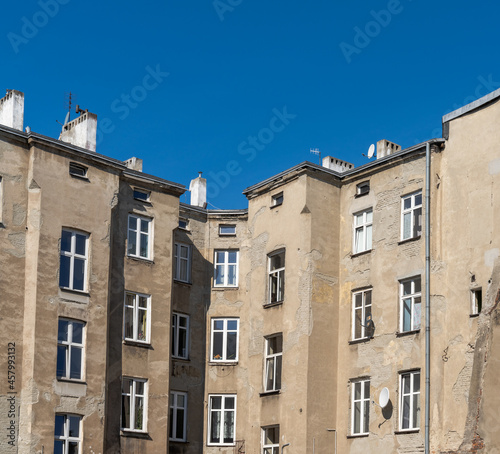 run-down and shabby apartment building block in Eastern Europe under a blue sky