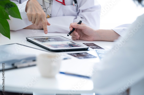 デジタルタブレットでレントゲンを見る医師のミーティング風景