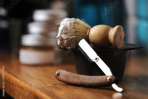 Set of shaving equipment and men's cosmetic products on wooden table, barbershop. shave concept with a straight razor, shaving brush and foam. beard care products for men on background.