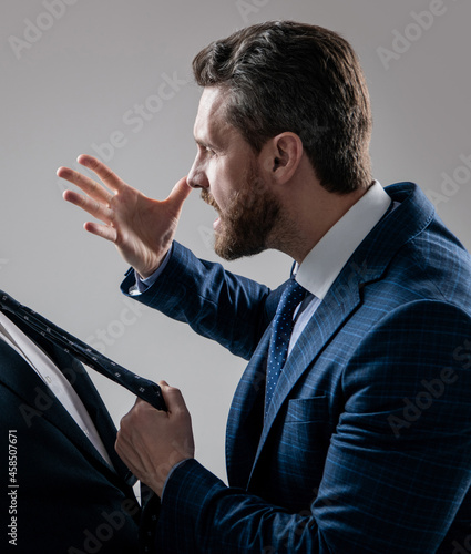 Aggressive lawyer in suit make threaten gesture pulling man necktie grey background, threatening