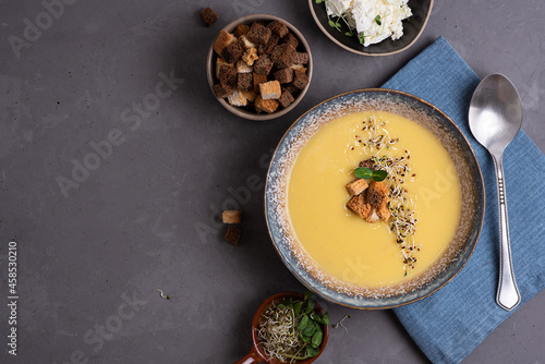 Homemade vegetarian squash cream soup with croutons and microgreens, healthy food concept.