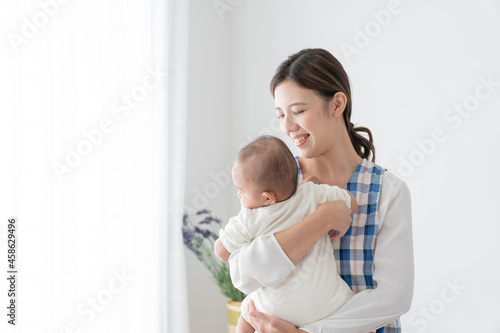 赤ちゃんを抱っこするベビーシッター（育児・子育て）