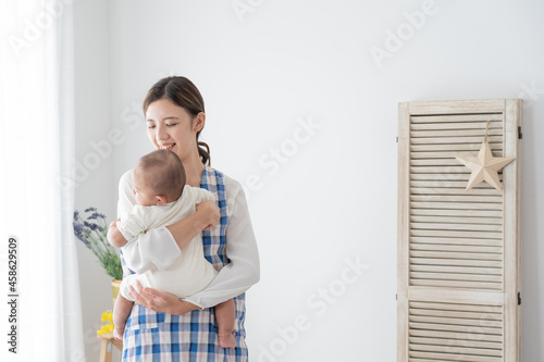赤ちゃんを抱っこするベビーシッター（育児・子育て）