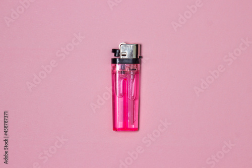 Pink lighter on a pink background. Cheap plastic lighter