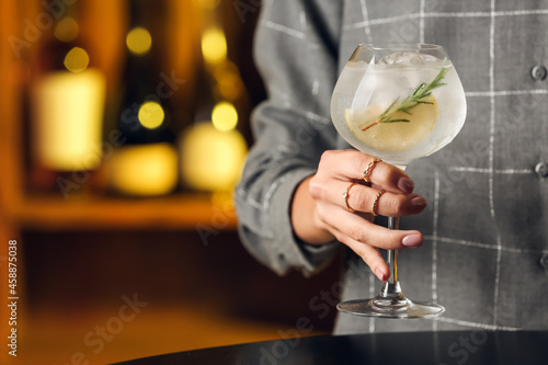 Woman with glass of cold gin tonic in bar