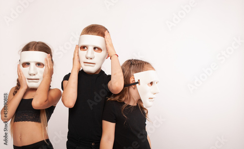 children actors in isolation on a white background in white masks on the face one child looks at the place to advertise the text. theatre day, performance announcement, mime day