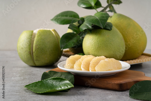 Fresh pomelo fruit on gray cement background.