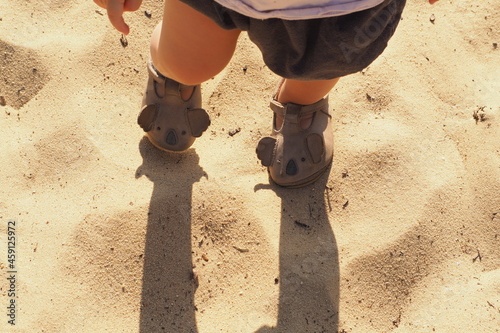 Widok na dziecko stojące w piasku z góry 