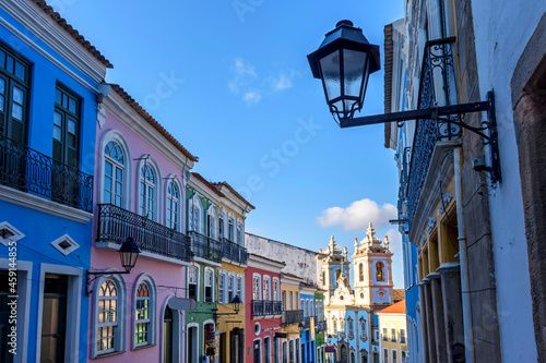 Old facades of colorful colonial-style houses and a tower of an old baroque church in Pelourinho, the famous historic center of Salvador, Bahia