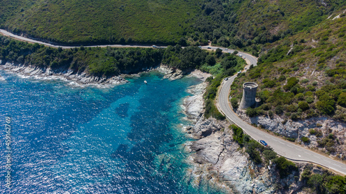 Aerial view of the ruins of the round Genoese tower of l'Osse on the Cap Corse, Corsica, France - Remains of a medieval lookout in the curve of a road overlooking the Mediterranean Sea
