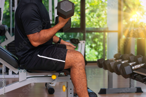 Fitness men workout with dumbbell at the gym in sunrise