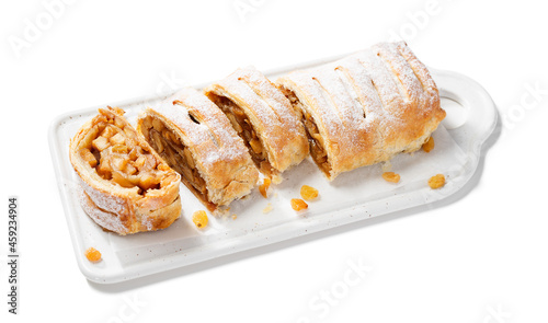 Traditional homemade apple strudel with caramelized apples and raisins. isolated on white background.