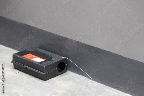 A black plastic rat trap on concrete floor. bait poison box for rat.