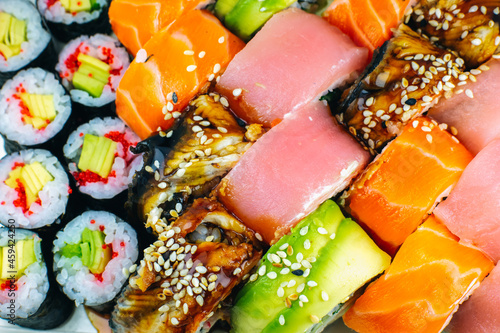 Tasty Colorful assorted Set of different type Sushi. Dinner in Japanese style. Healthy food. Filadelfia and Maki sushi rolls with Avocado, Tuna, Salmon, fish and Prawns. Close up view. Wallpaper.