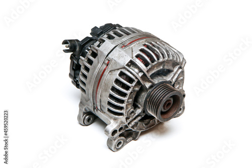 The old used and broken alternator from the motor vehicle isolated on a white background. 