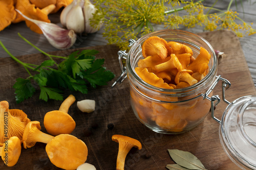 Preserving chanterelle mushrooms in a jar with spices and herbs. Pickling wild edible mushrooms