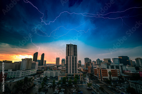 Rare lightning bolts over the downtown San Diego city skyline during a rain storm at sunset