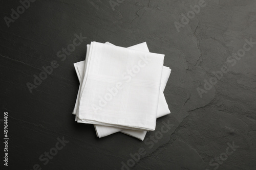 White handkerchiefs folded on black table, top view