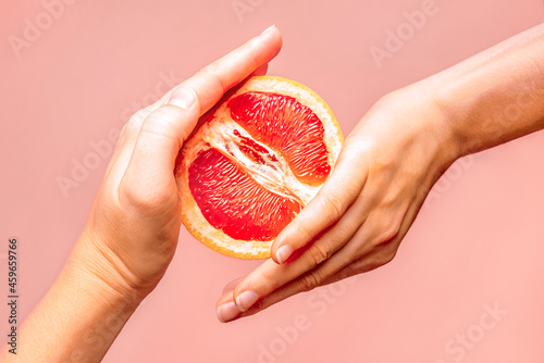 Hands holding grapefruit. Symbol of vagina. Female health, sex, menstruation concept