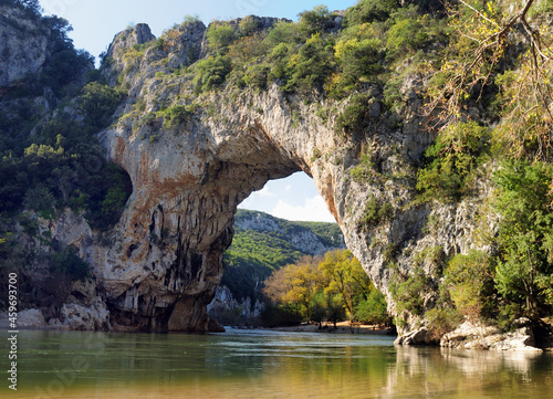 Rock Arch Pont D'Arc In The Canyon Of The Gorges De L'Ardeche With Reflections On The River Ardeche In France On A Beautiful Autumn Day With A Clear Blue Sky