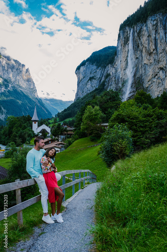 Lauterbrunnen valley, the village Lauterbrunnen, Staubbach Fall, and Lauterbrunnen Wall in the Swiss Alps, Switzerland. Europe Lauterbrunnen valley, a couple Caucasian man and Asian woman on vacation