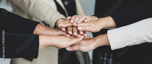 Close up shot of holding hands of unidentified unrecognizable successful female businesswoman group together in formal business suit wears empower encourage as trust teamwork partnership agreement