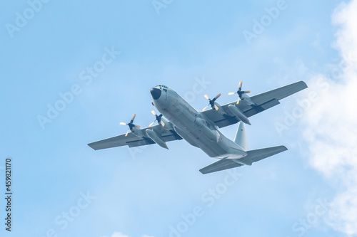 Military transport aircraft conducting training flight in the blue sky background.